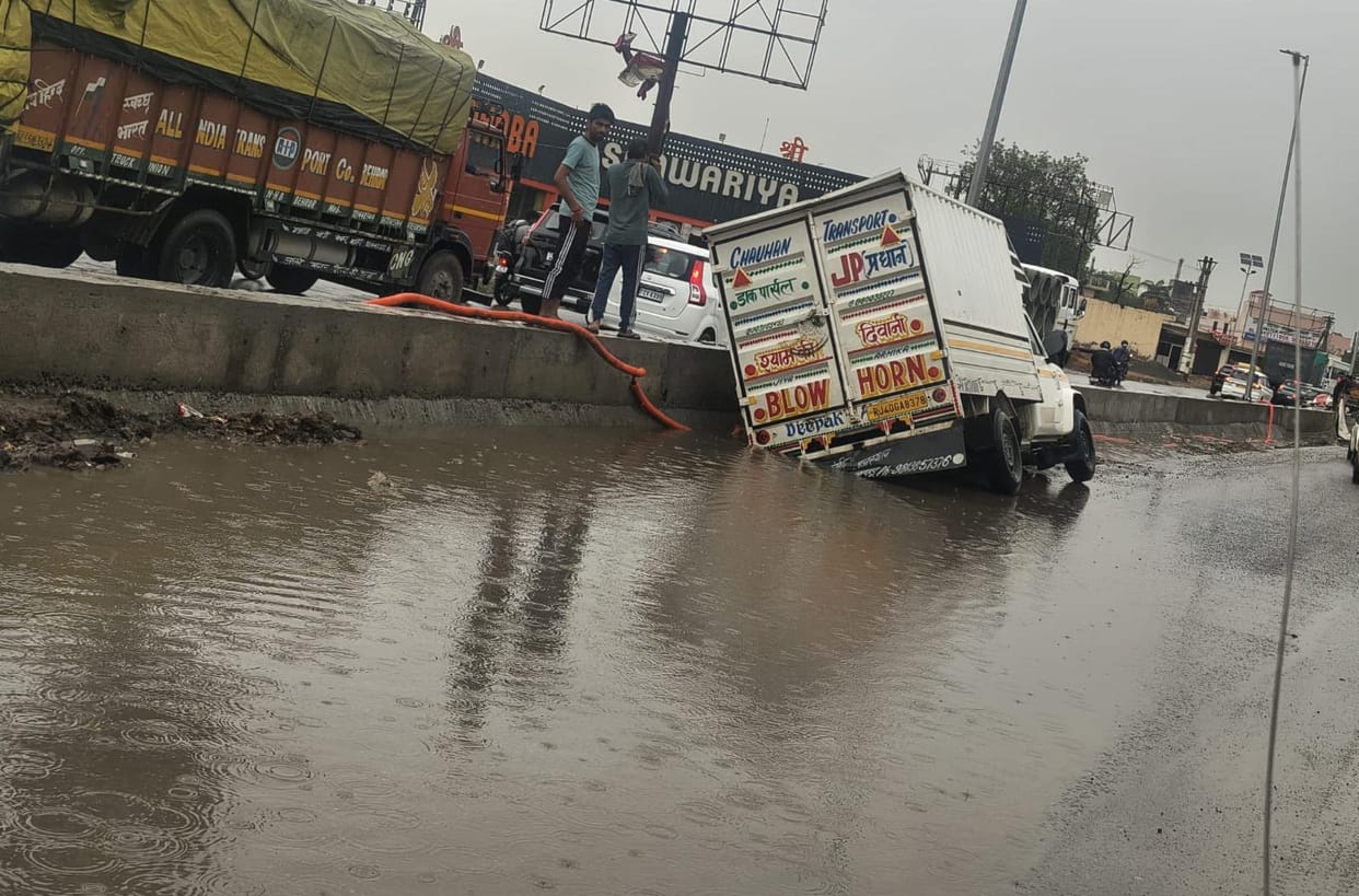 Vehicle stuck in a pit near Malpura due to rain.