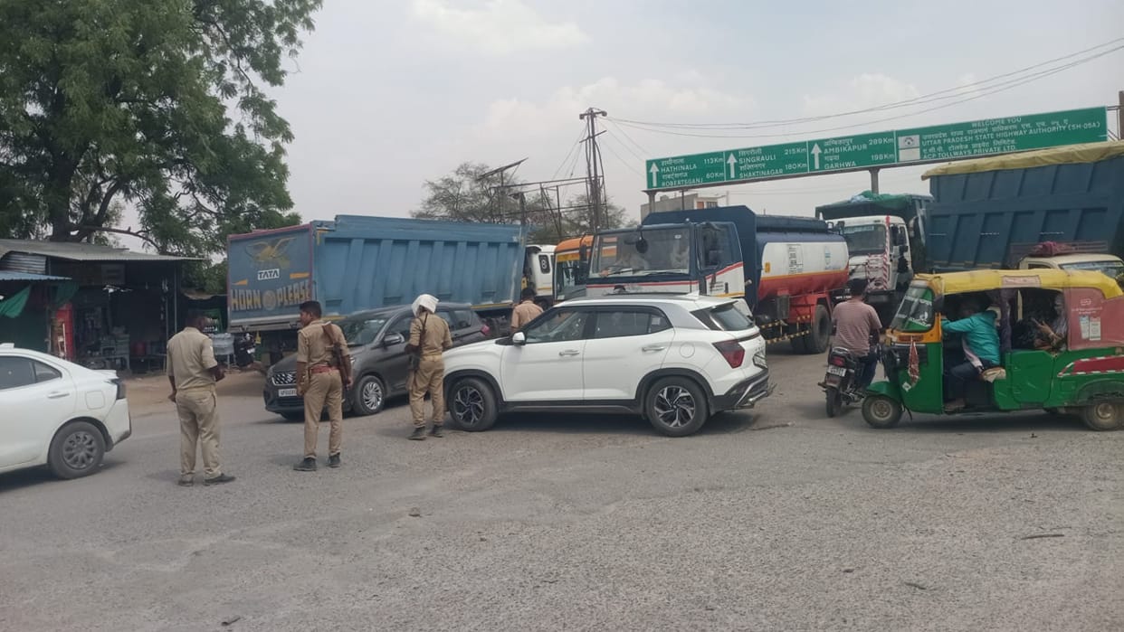 Traffic jam caused by bad road; commuters distressed in the scorching heat.