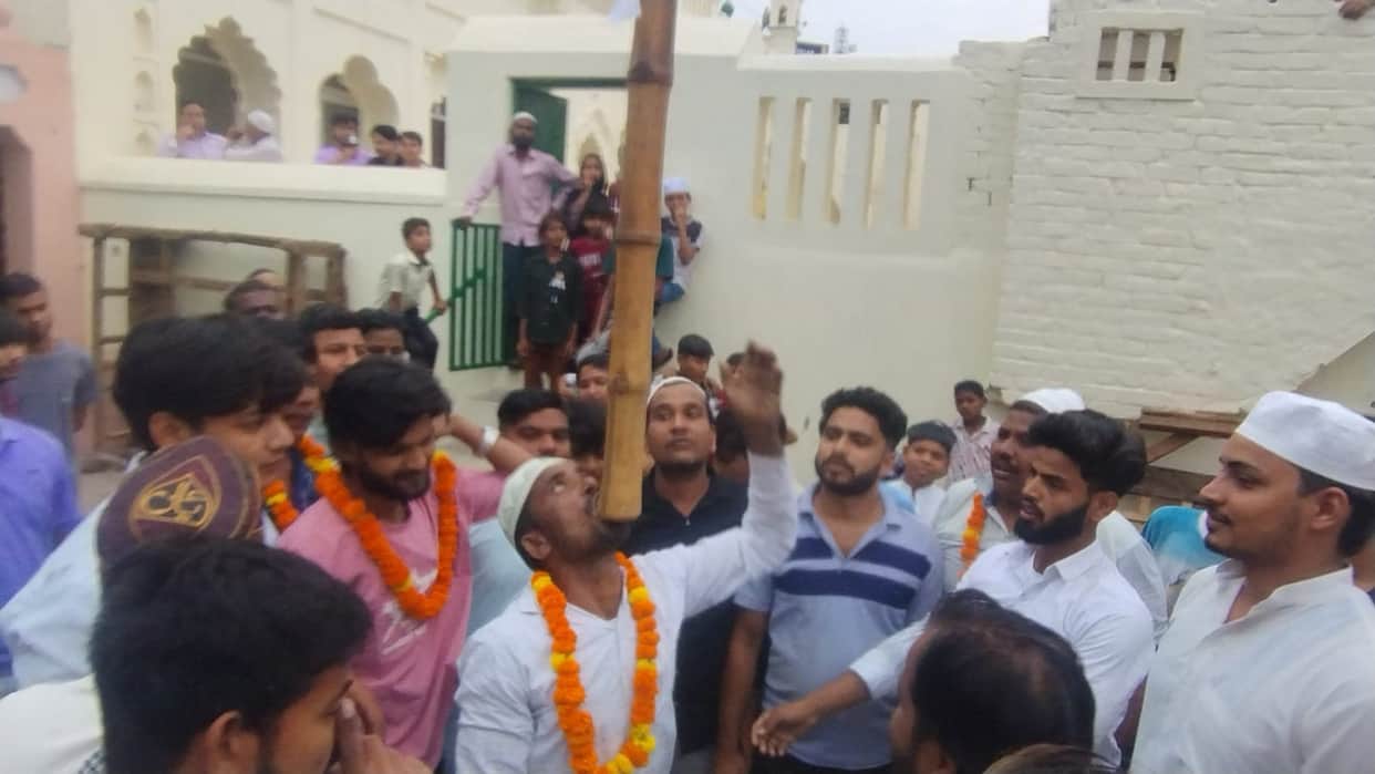 Youth lifts 50 kg bamboo with his teeth during procession.