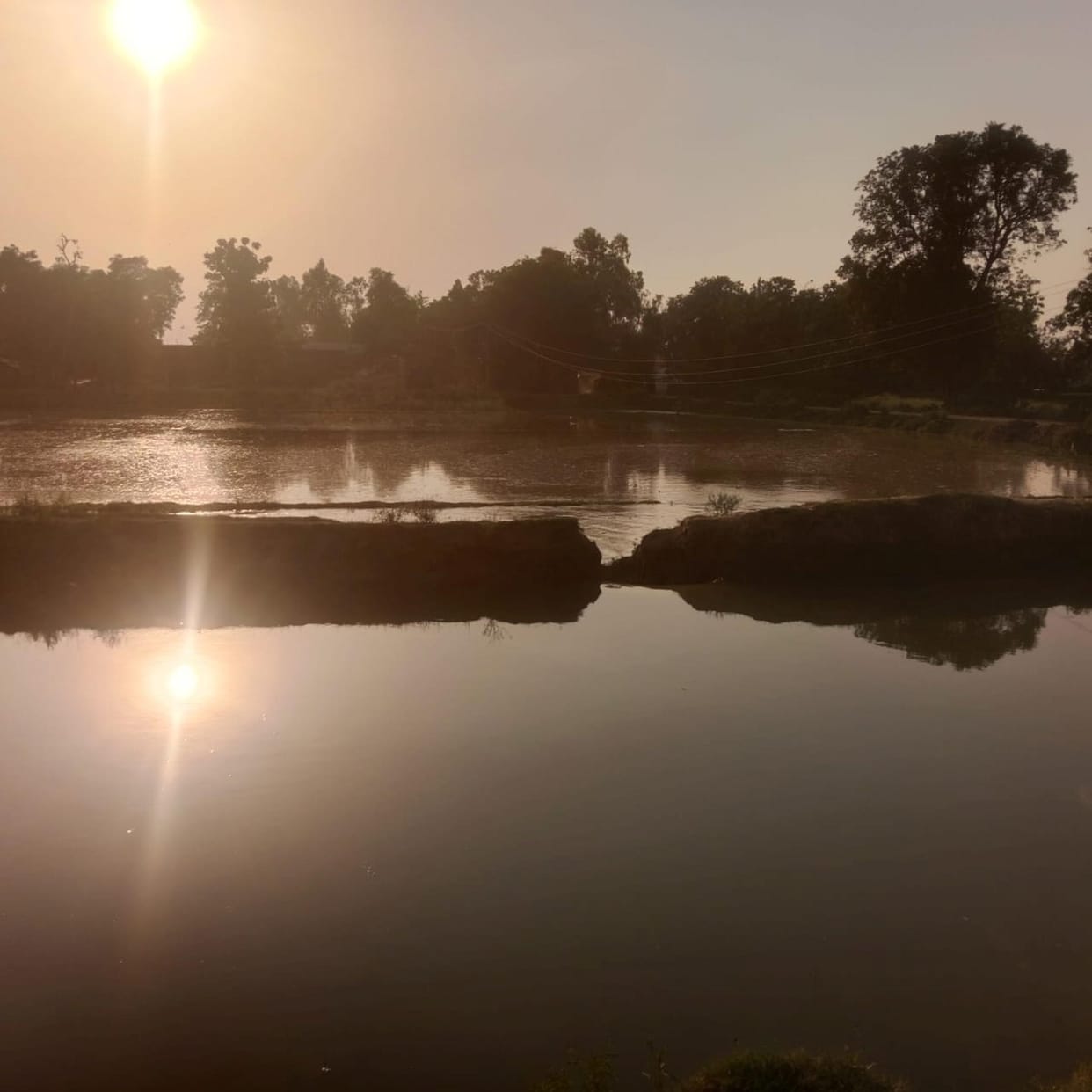 Canal bank breaches, fields submerged.