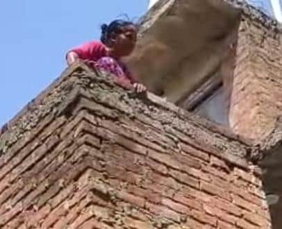 Woman climbs onto roof and pours diesel on herself in protest against drain construction.