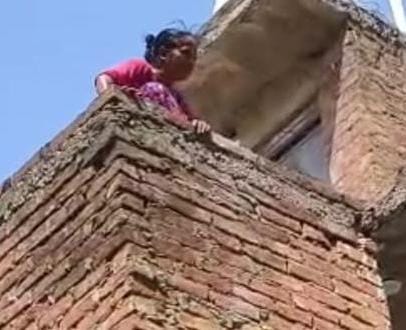 Woman climbs onto roof and pours diesel on herself in protest against drain construction.