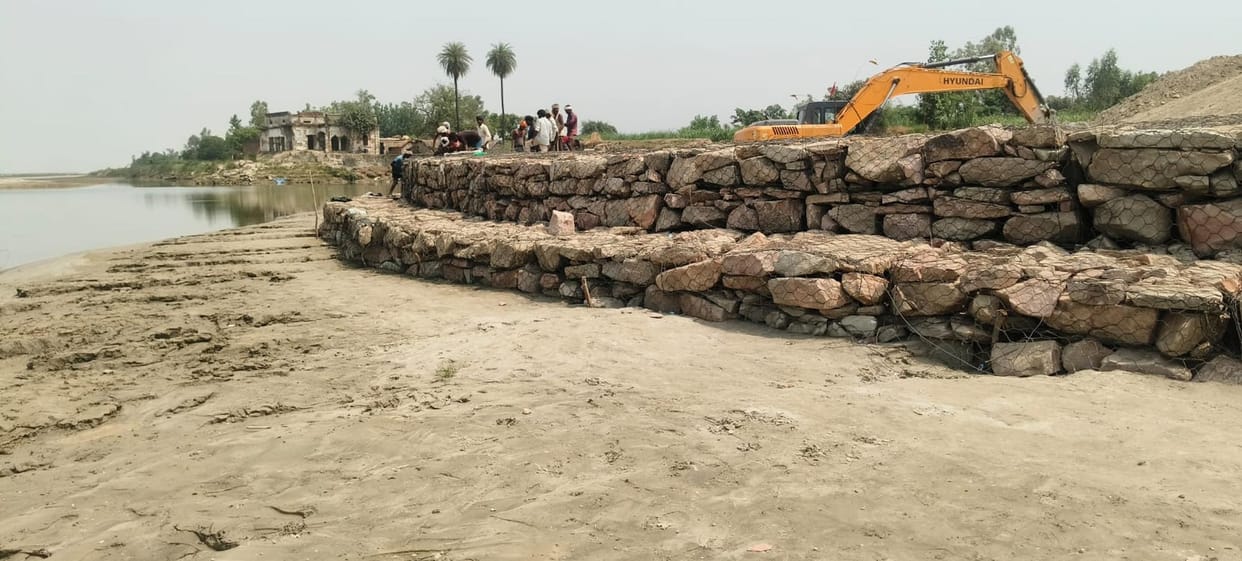 Boulders being placed without a base; embankment at risk.
