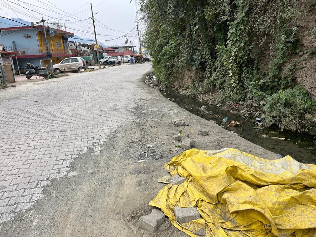 Paver block work on the road in Shamti stalled; risk increases due to lack of drainage system.