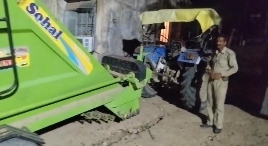 Tractor and reaper machine seizing while excavating soil at night.