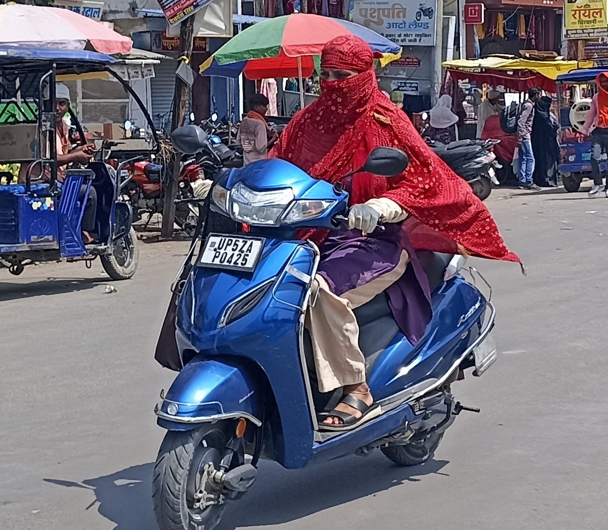 Scorching sun; people stepped out with faces covered; rain likely.