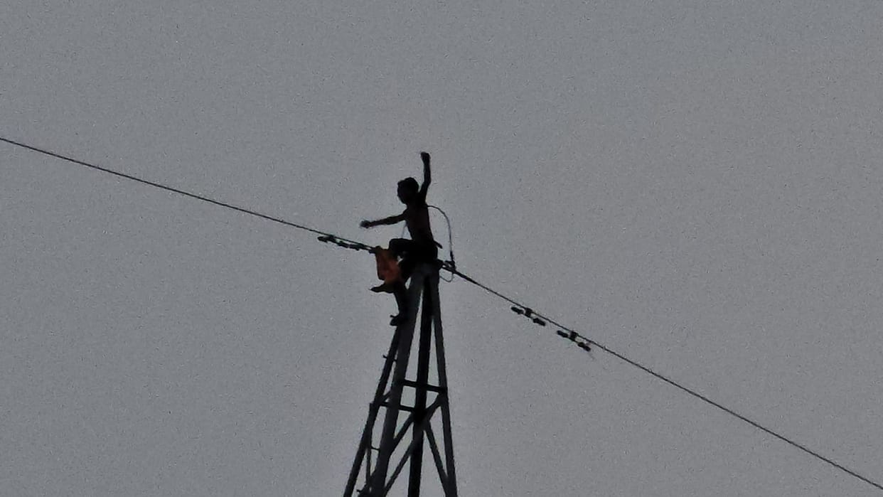 Youth climbs electricity tower, chanting 'Jai' to Trilochan Mahadev.