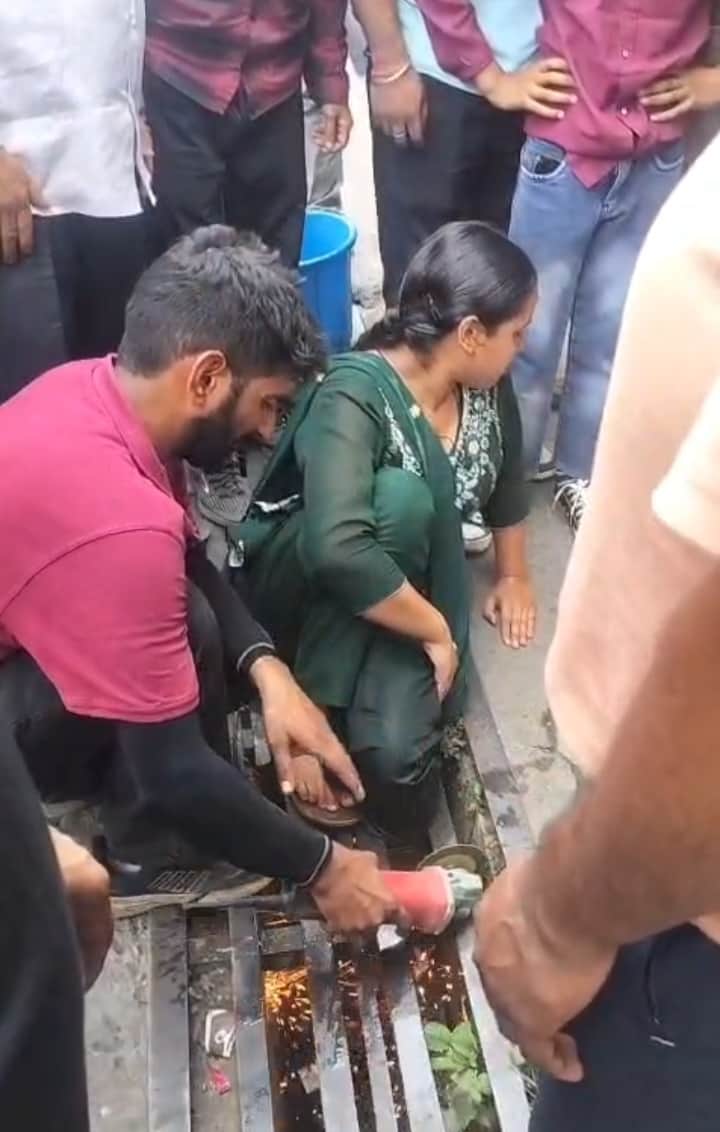 Woman's leg gets stuck in the iron grating outside a public toilet.