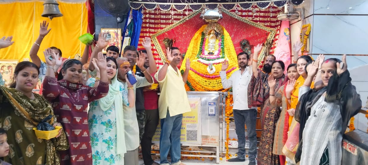 Khatu Naresh dressed in yellow clothes, devotees gathered