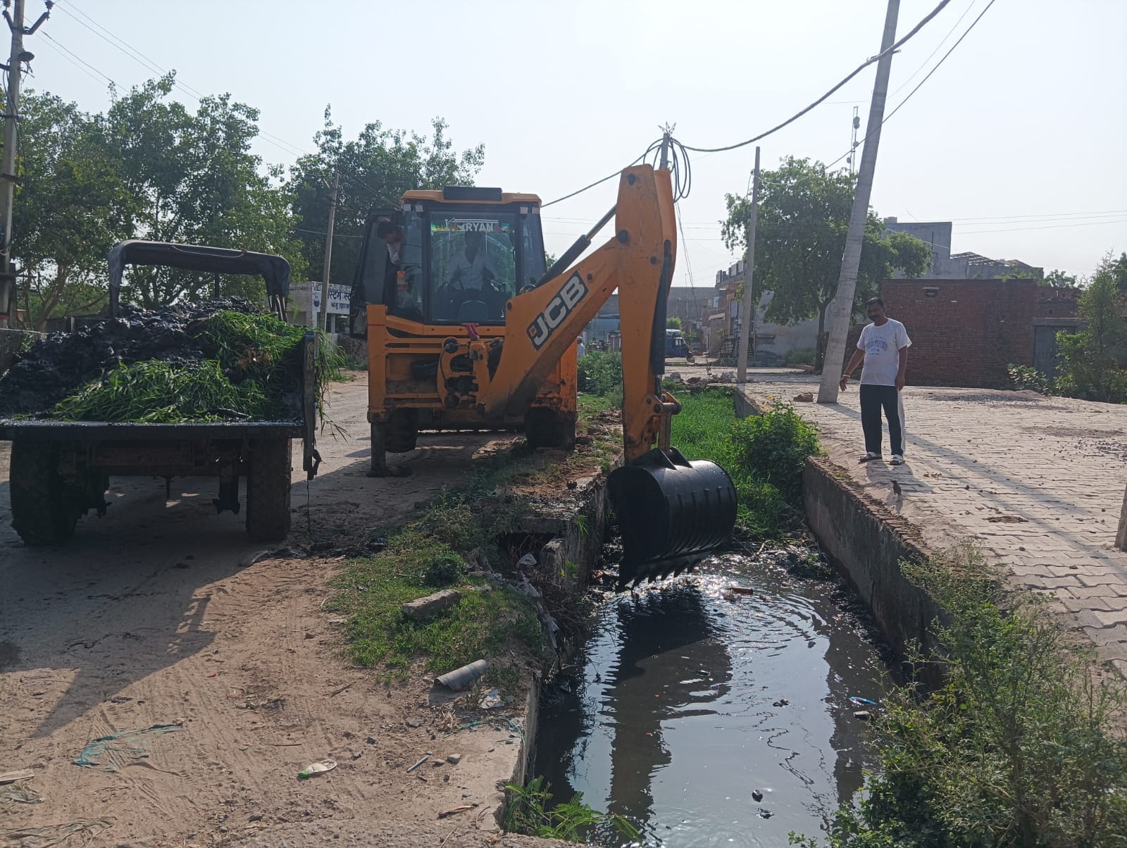27jjrp05- गांव बहु में बडे़ नाले की सफाई बुलडोजर से करता कर्मचारी। स्रोत : ग्रामीण