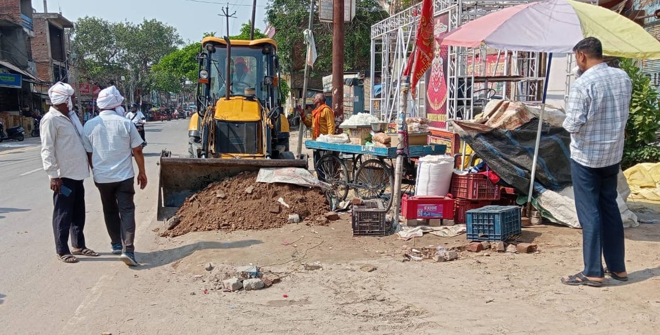 फोटो-34- जेसीबी से फुटपाथ का अतिक्रमण हटवाते कर्मी। संवाद