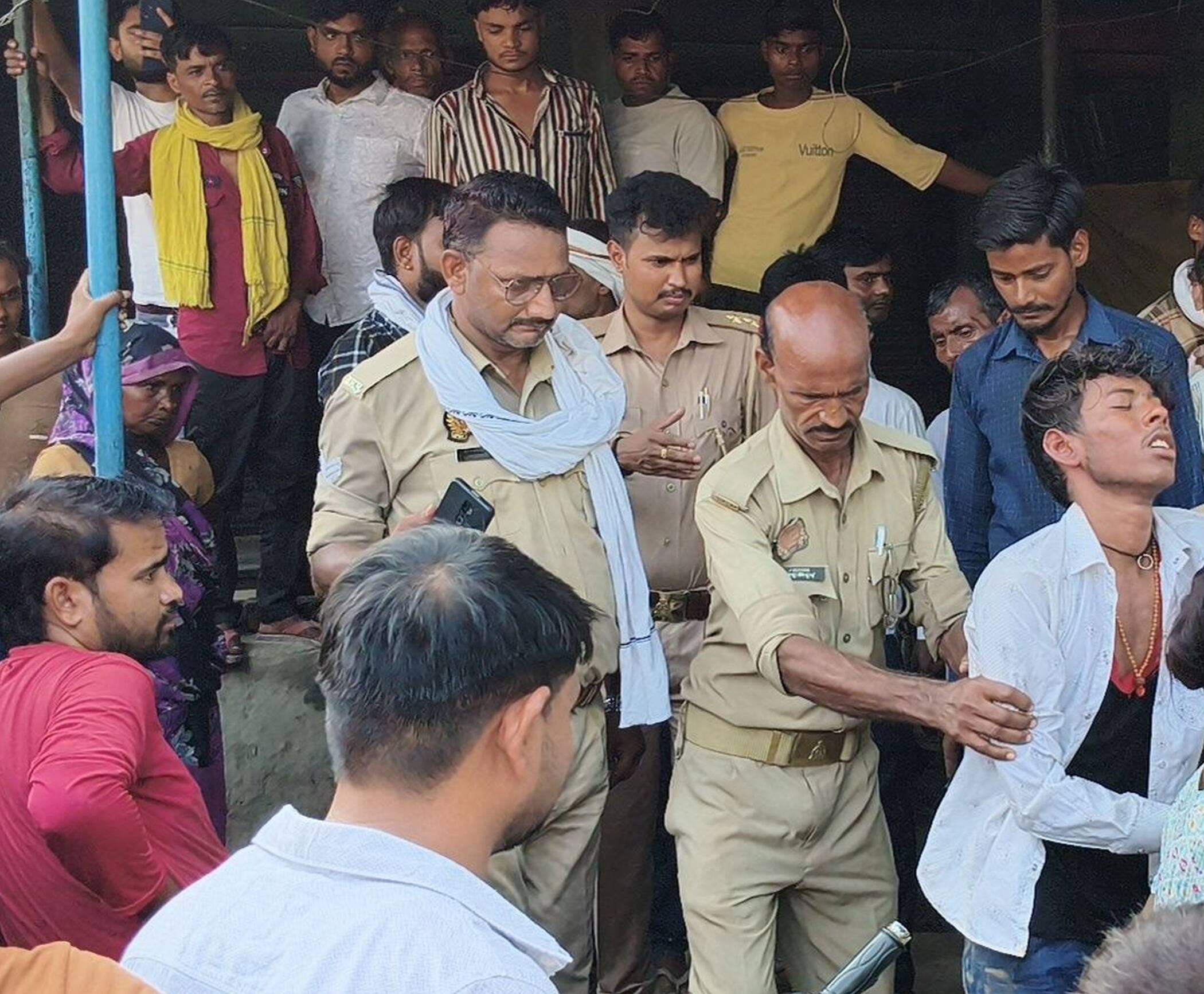 फोटो-35-युवक की पिटाई के बाद ले जाती पलिस व मौजूद ग्रामीण । संवाद