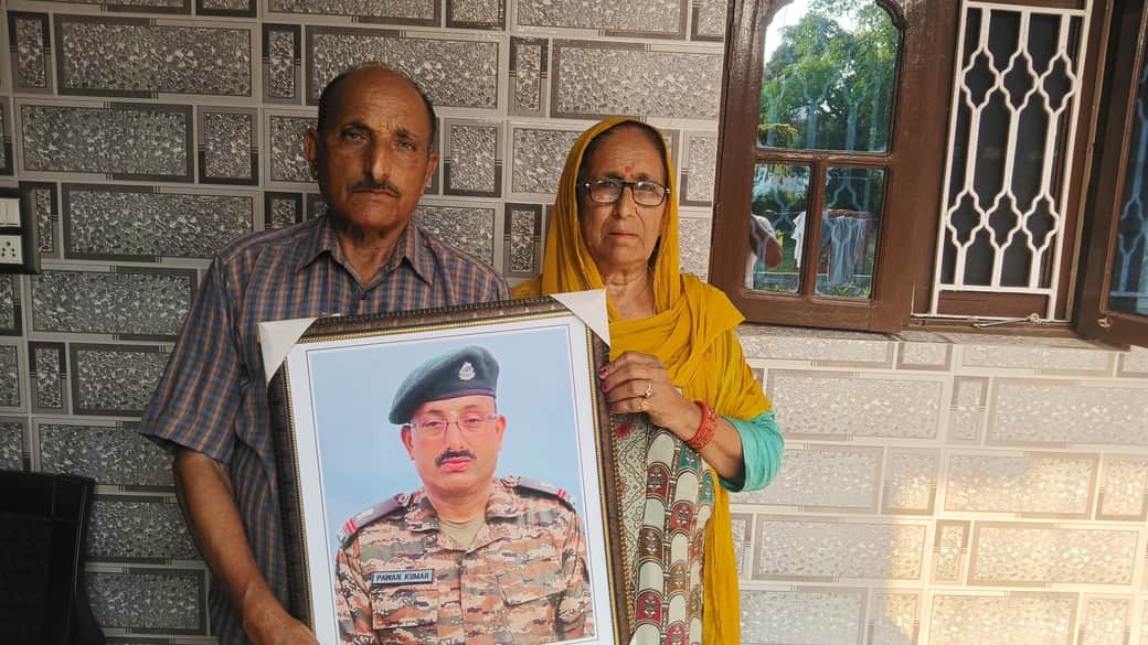 शाहपुर के वीर सपूत सूबेदार मेजर पवन जरियाल के माता-पिता अपने बेटे की तस्वीर के साथ।-जागरुक पाठक