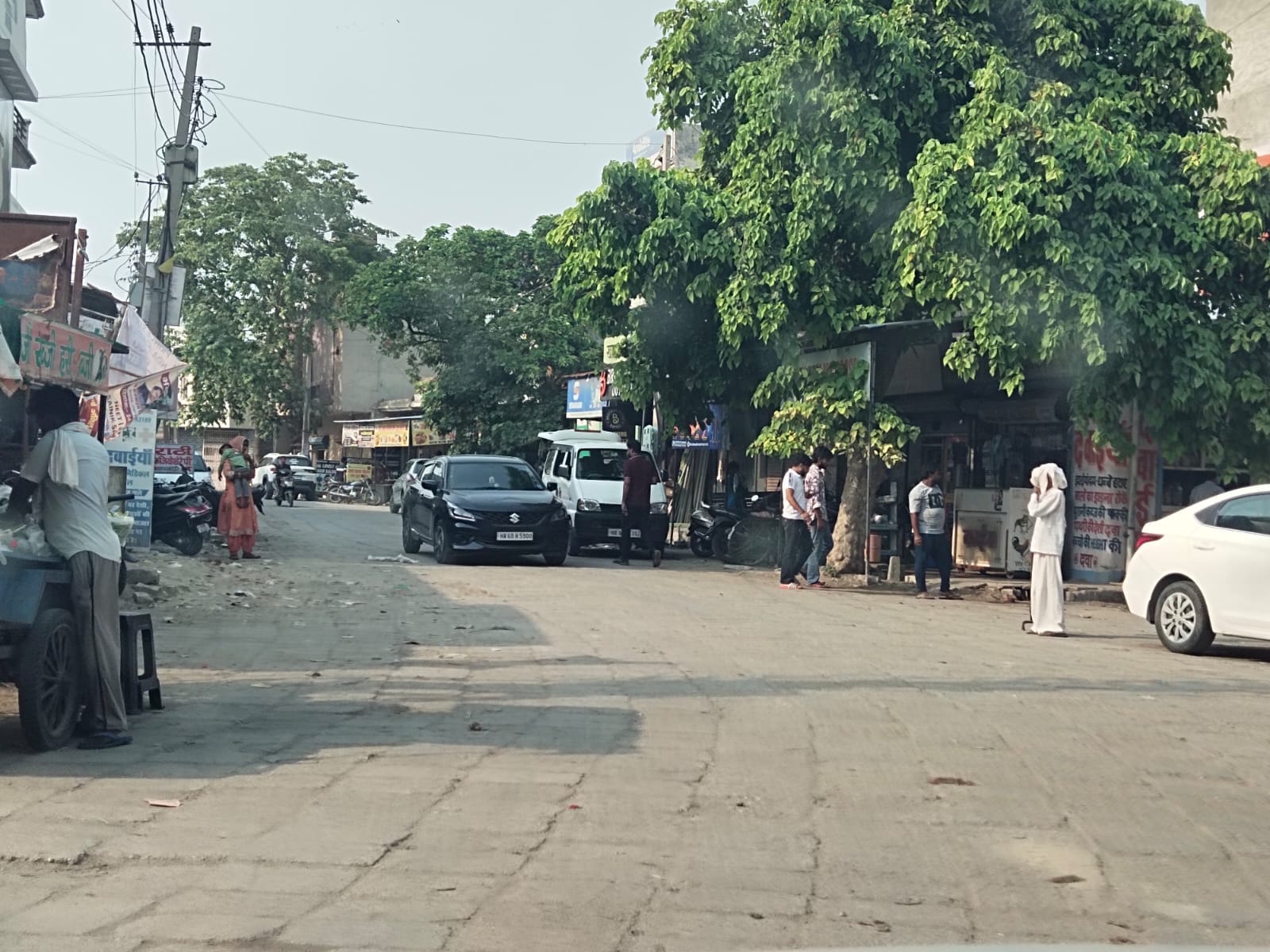 बापौली अड्डे पर खुले आसमां के नीचे इंतजार में खड़े यात्री। संवाद