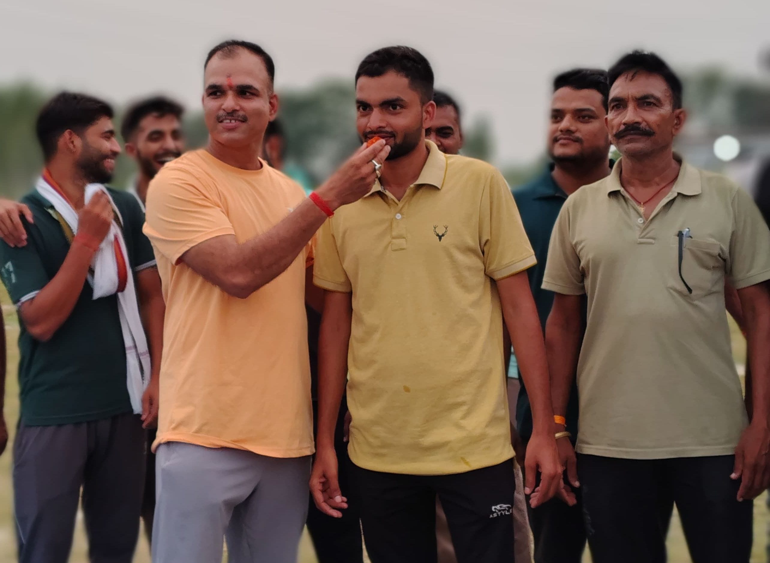 फोटो- 12- सुभाष को मिठाई खिलाते एकेडमी प्रशिक्षक धीरज दीक्षित साथ में अन्य। स्रोत: स्वयं
