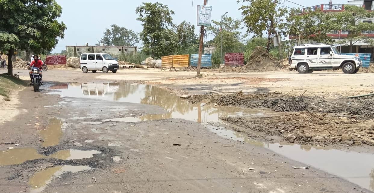 Pipe damaged during overbridge construction; water flowing onto the road