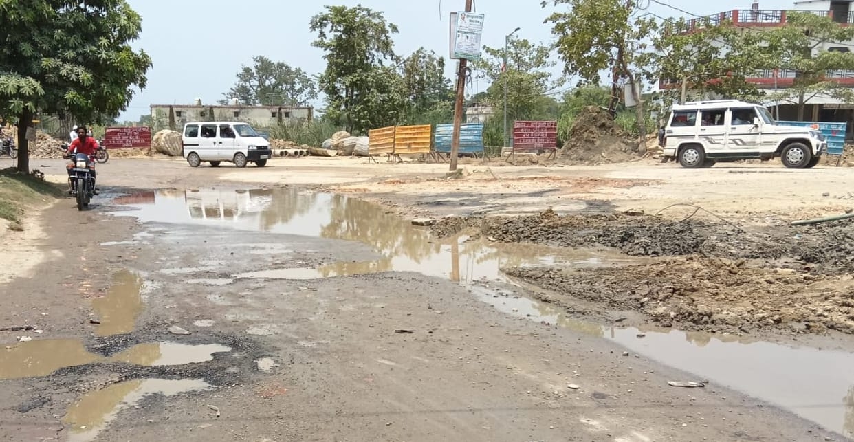 Pipe damaged during overbridge construction; water flowing onto the road