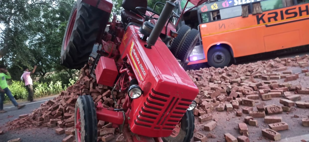Brick-laden tractor-trolley overturns after collision with DCM truck; driver has a narrow escape.