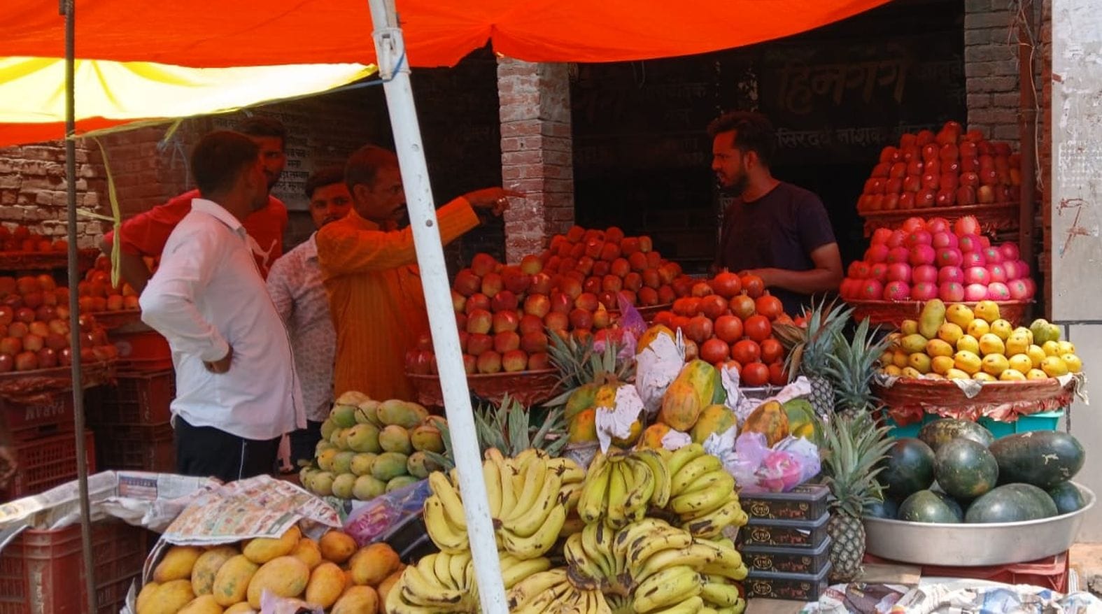 शहर में सब्जी मंडी रोड पर फल की दुकान से खरीदारी करते लोग।