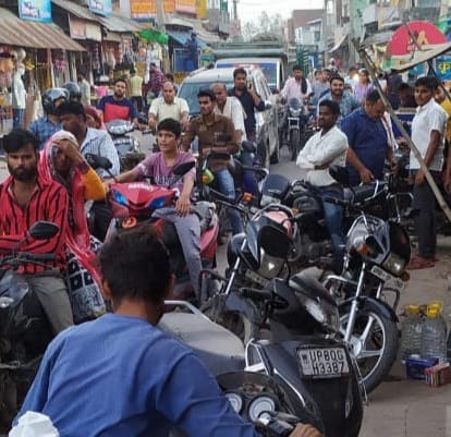 Goods outside shops in the market, drivers stuck in traffic jam
