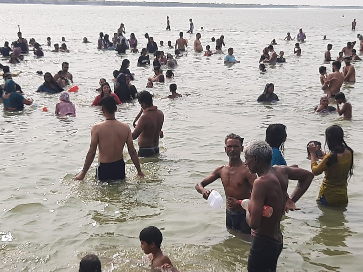 Devotees throng the banks of the Ganges on Jyeshtha Purnima; chants of 'Har-Har Gange' resound.