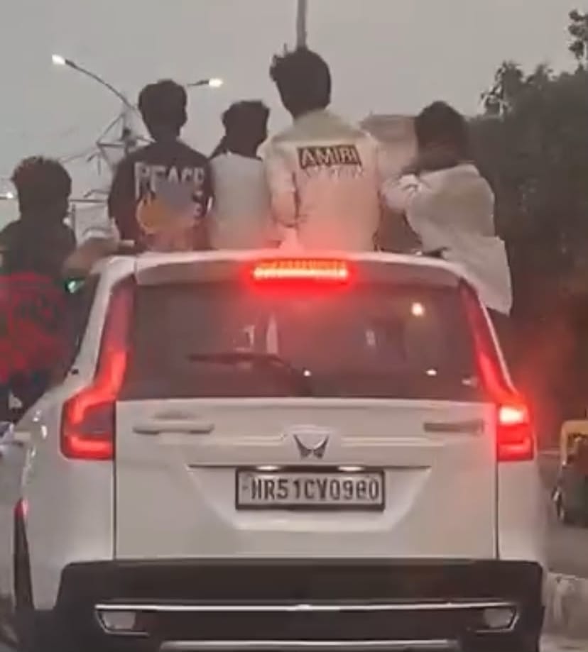 Performing stunts by leaning out of the sunroofs and windows of moving cars.