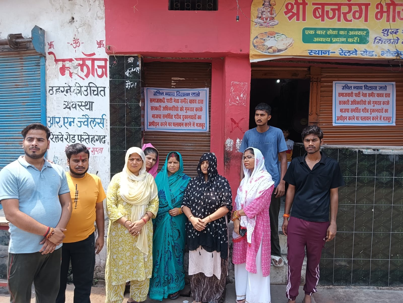 फोटो-39 रेलवे स्टेशन रोड पर दुकानों के बाहर पोस्टर लगाकर न्याय की मांग करतीं महिलाएं। संवाद