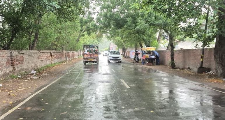 भिवानी में शाम के समय आई तेज बारिश में से गुजरते वाहन। 