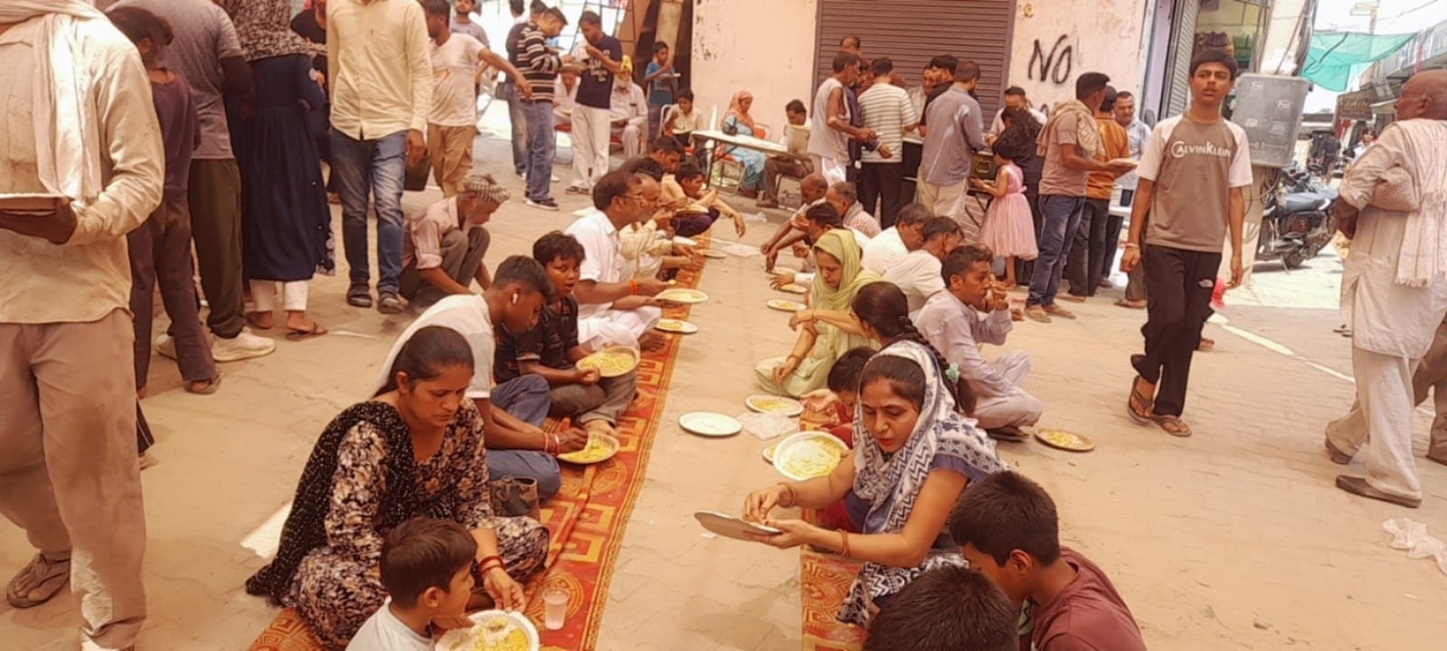 राधाकृष्ण मंदिर में प्रसाद ग्रहण करते भक्त।। संवाद