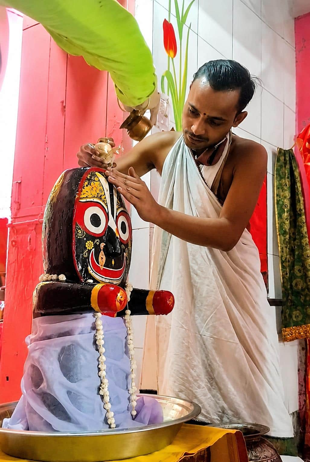 शहर की जैन गली स्थित जगन्नाथ धाम मंदिर में भगवान जगन्नाथ का अभिषेक करते पुजारी। स्रोत : स्वयं