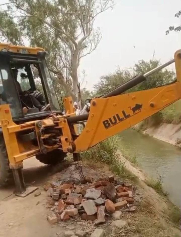 बवानीखेड़ा माइनर में बनी अवरोधक दीवार को हटाती जेसीबी 