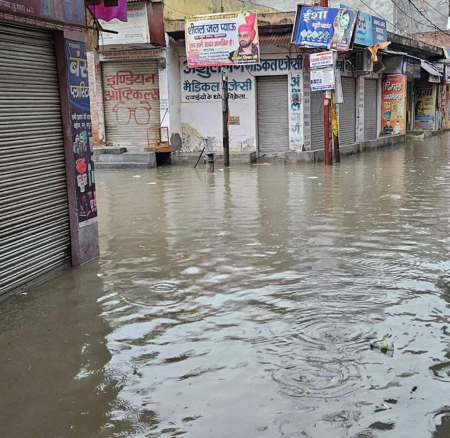 Rain leaves fields and threshing grounds submerged; water also enters homes, shops, and schools.