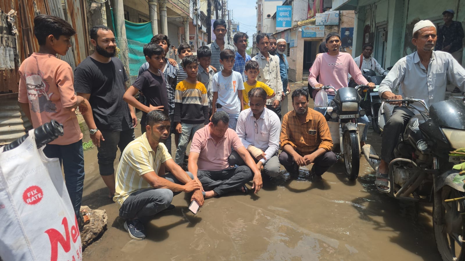 बुरहानपुर में विरोध स्वरूप कीचड़ में बैठे पार्षद