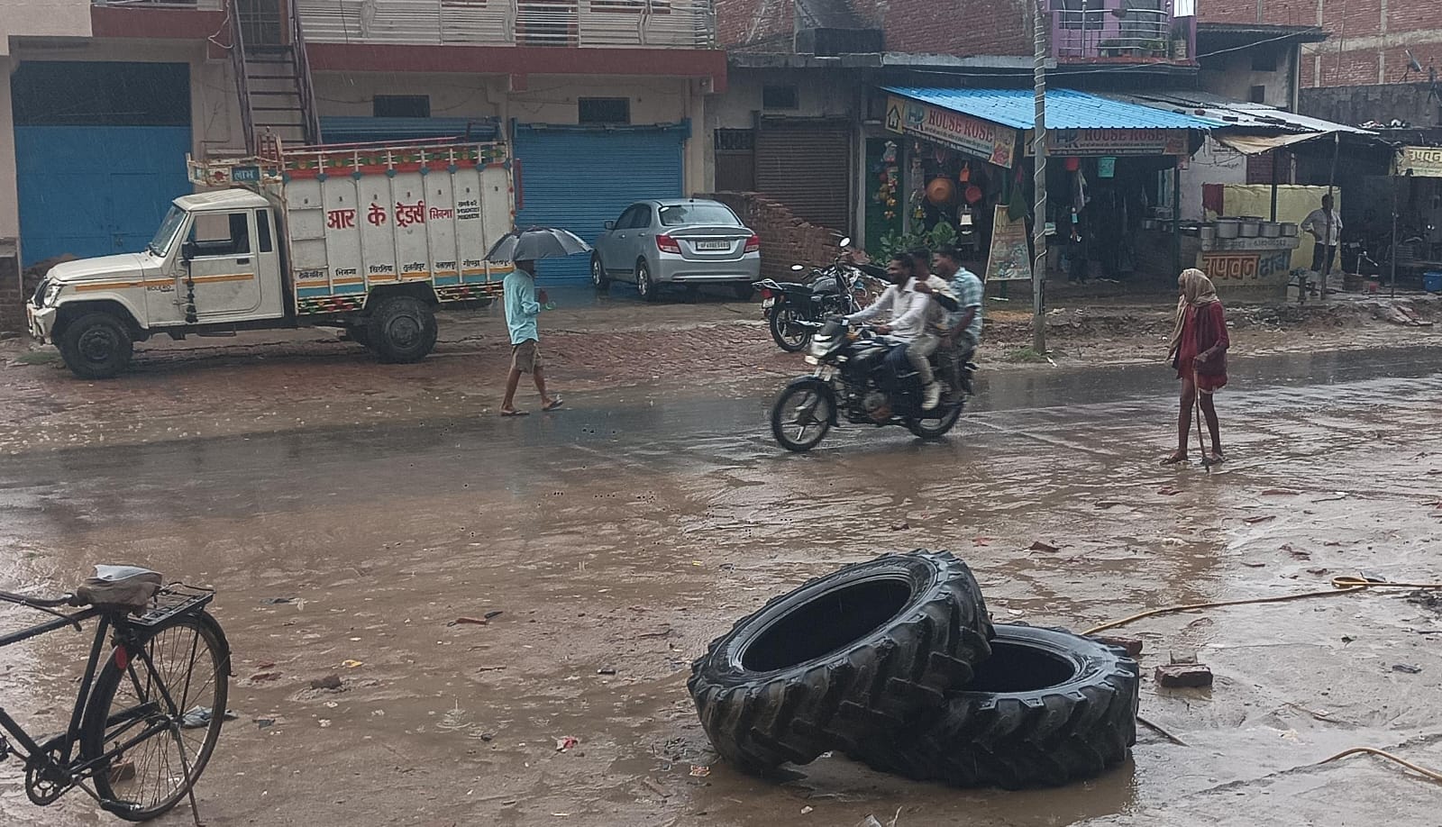 भिनगा में बारिश के बीच निकलते लोग।