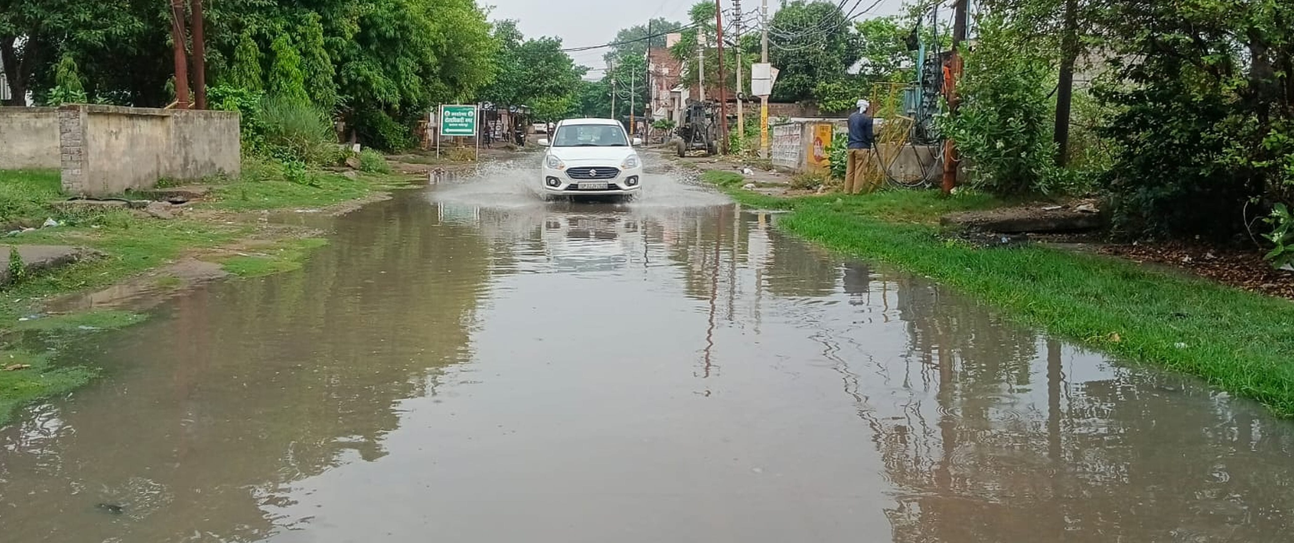 फोटो-02-शहर के रानी कालोनी में बारिश के बाद भरे पानी से निकलते वाहन। संवाद