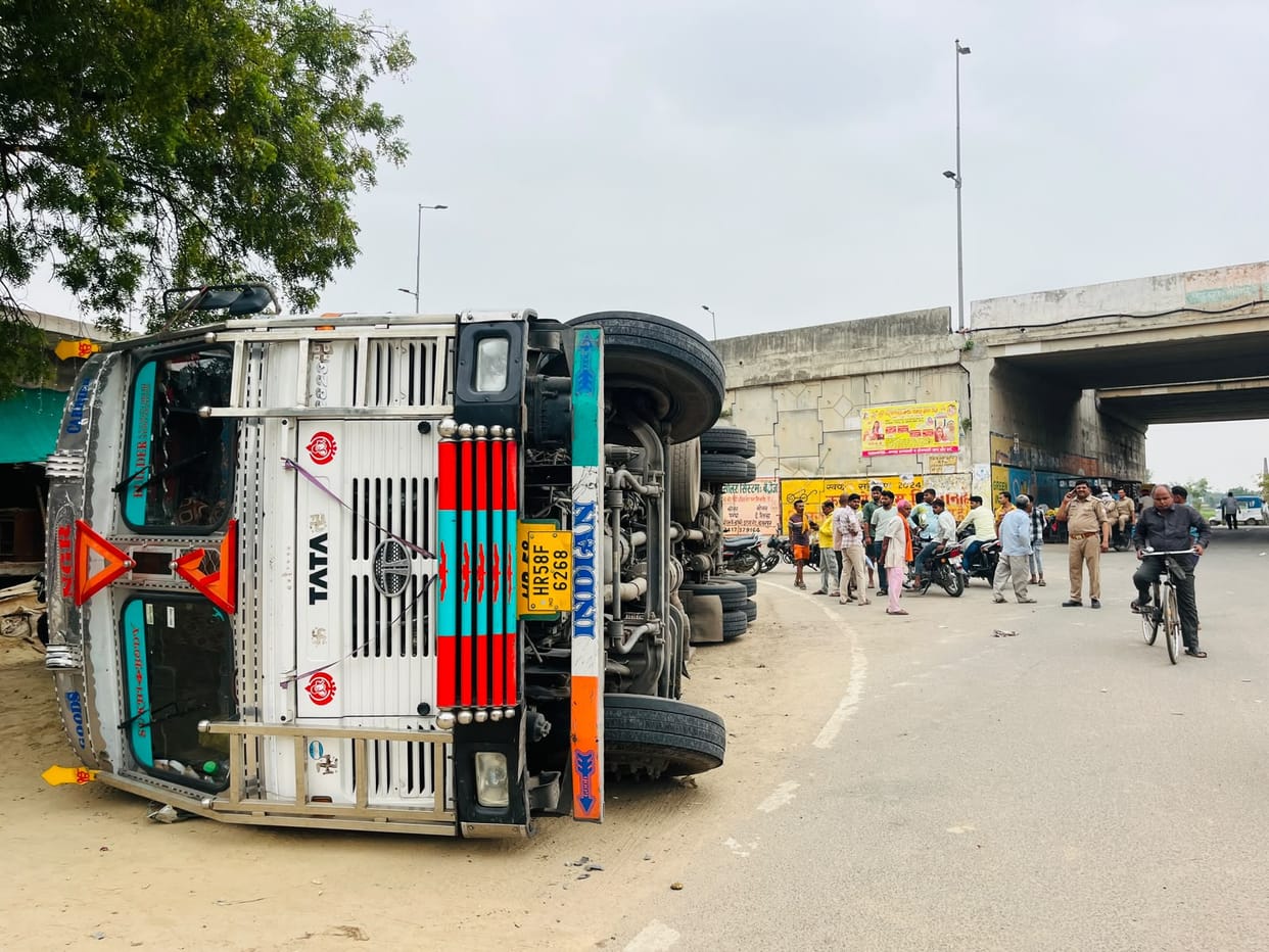Container truck overturns after breaking through toll plaza boom barrier and fleeing.