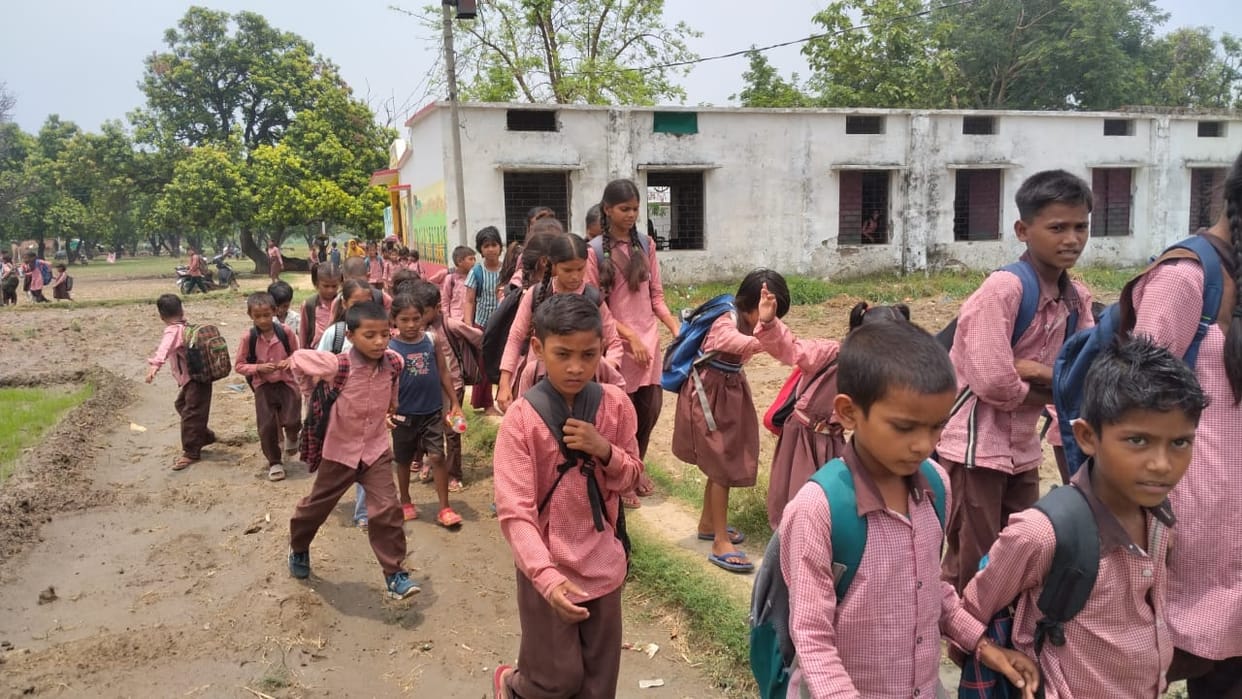 A paved road has been pending for 44 years; children and teachers reach school covered in mud.