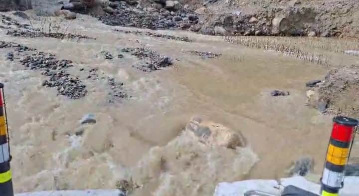 Telgad River overflows in Harsil; construction material for bridge buried under debris.
