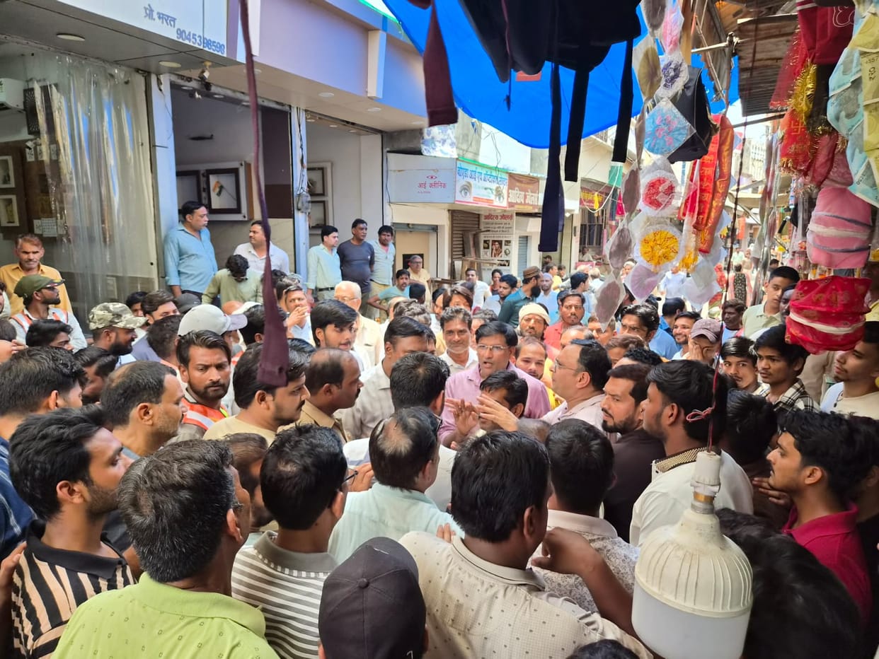Demolition work near the drain; traders lie down in front of the JCB; commotion ensues.