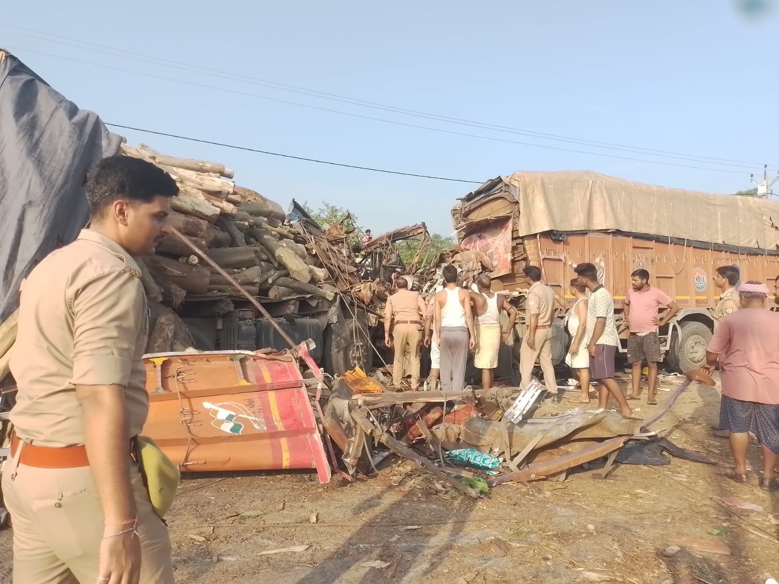 बौद्ध परिपथ पर ट्रकों की भिड़ंत के बाद बिखरा मलबा, जांच करते पुलिस कर्मी।