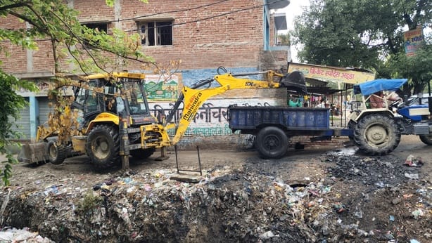 फोटो-1- नाला की गंदगी को ट्रैक्टर-ट्रॉली में डालती जेसीबी।संवाद