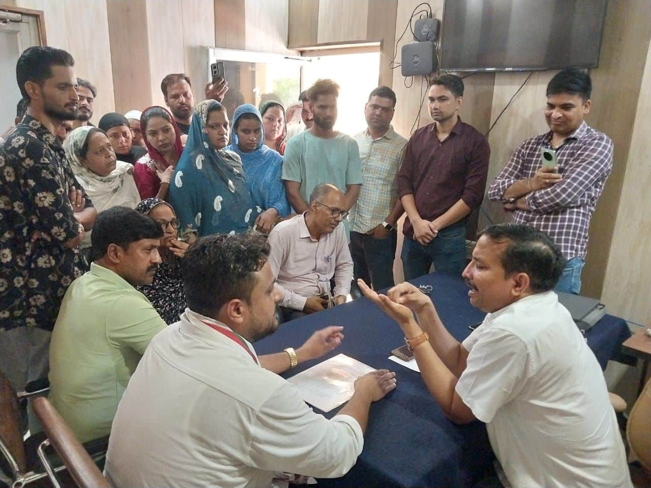 फोटो-4-एसओजी प्रभारी से शिकायत करते पीड़ित युवक के परिजन व मोहल्ले के लोग। स्रोत: पाठक