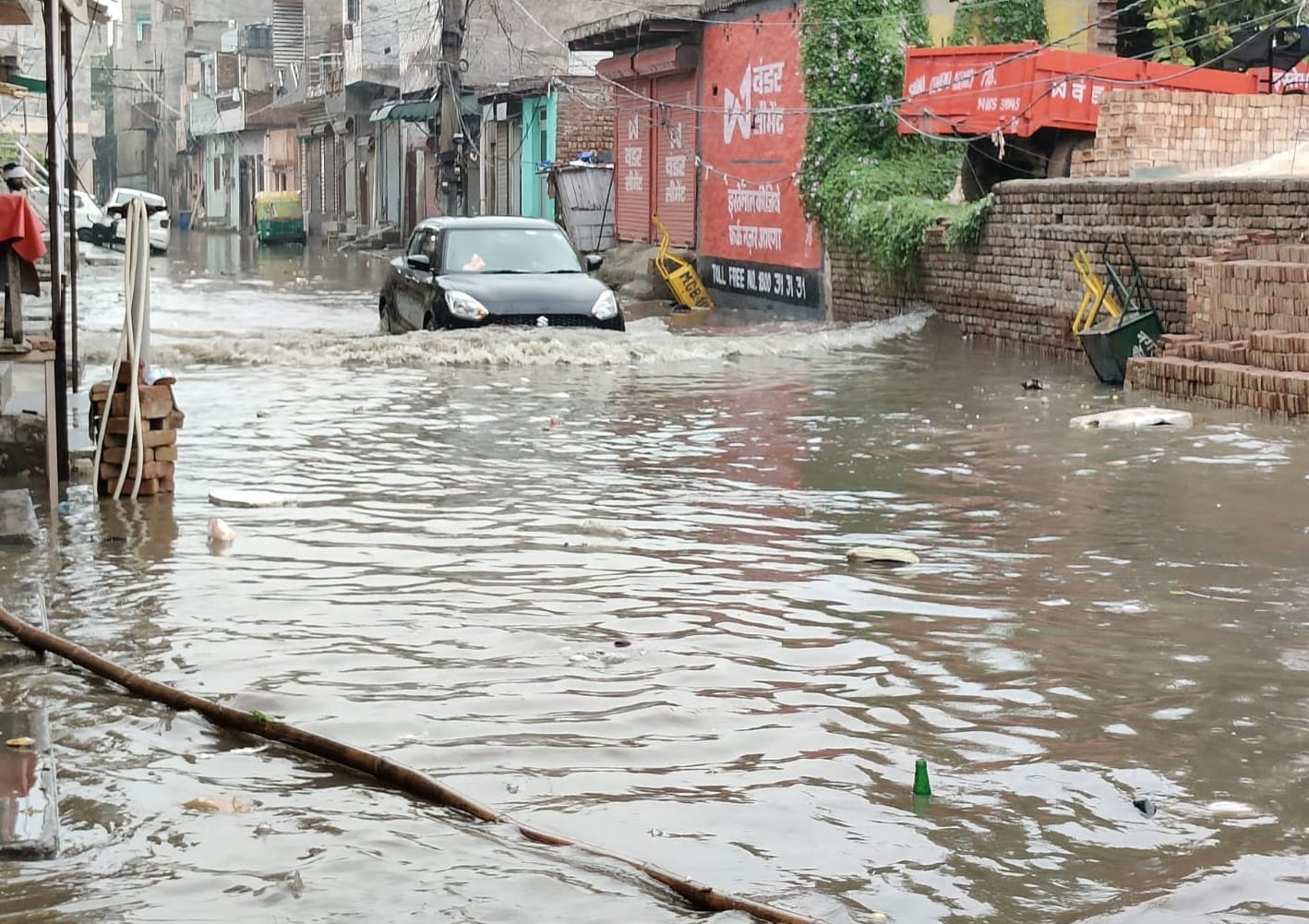 -फोटो 57 : शहर के बाग वाला मोहल्ला में भरा बारिश का पानी और गुजरती कार। संवाद