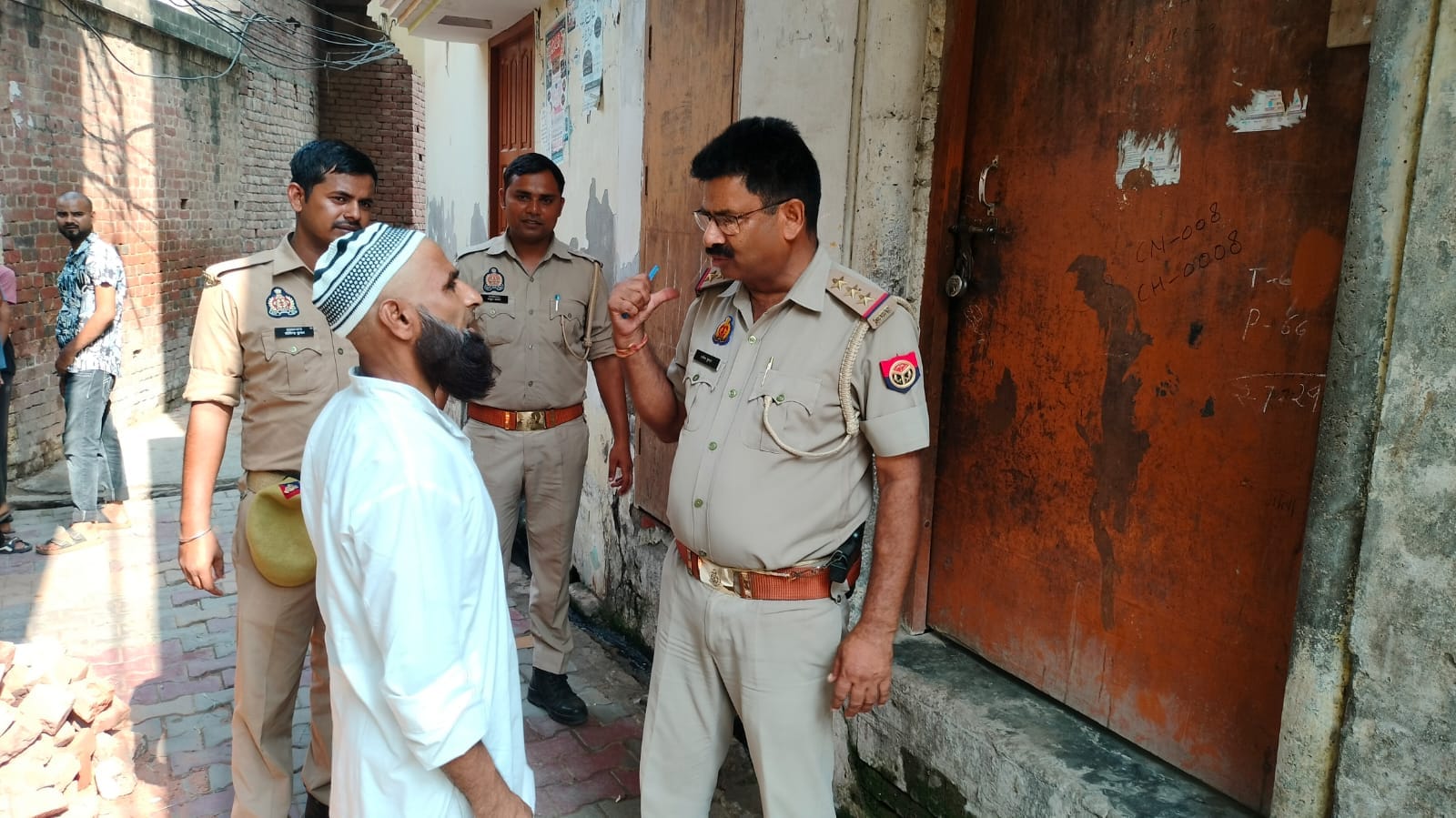 खतौली के गांव फुलत में अब्दुल रहमान के घर के बाहर ग्रामीणों से जानकारी करती पुलिस। संवाद