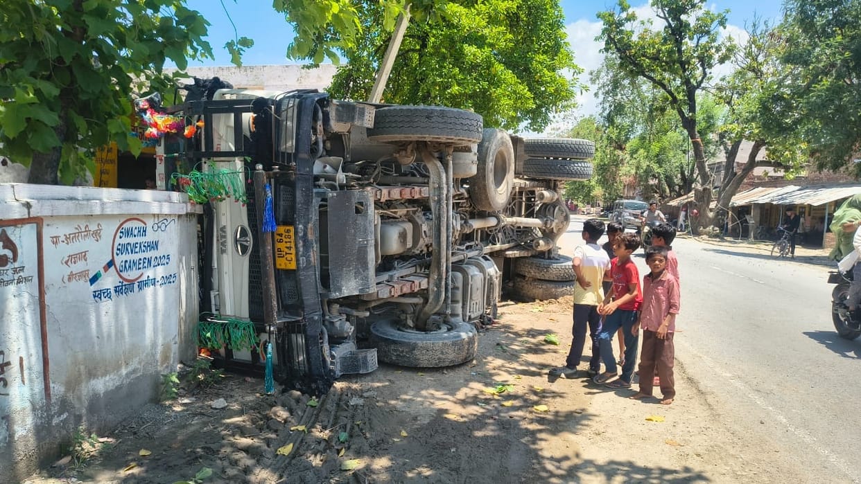 Gravel-laden truck overturns while reversing.