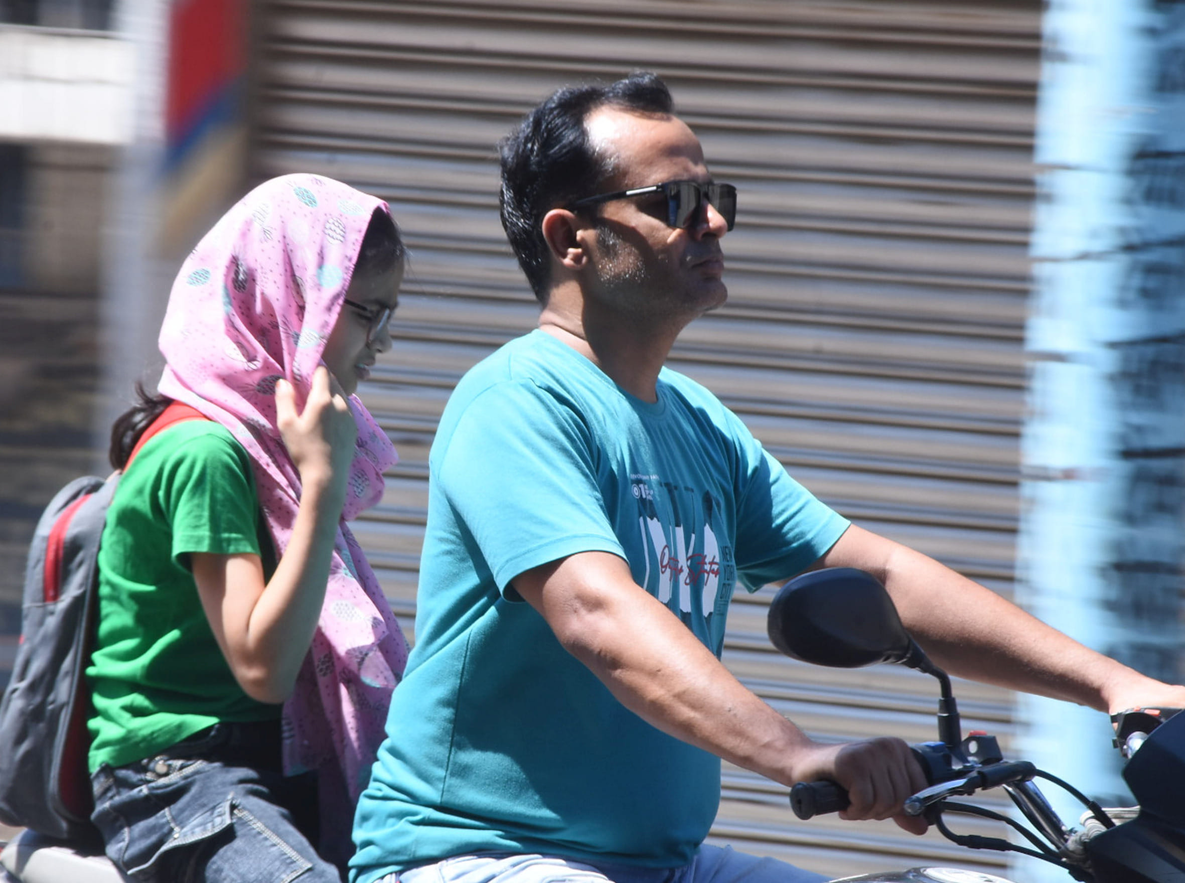 बहराइच में चिलचिलाती धूप में गुजरते लोग।
