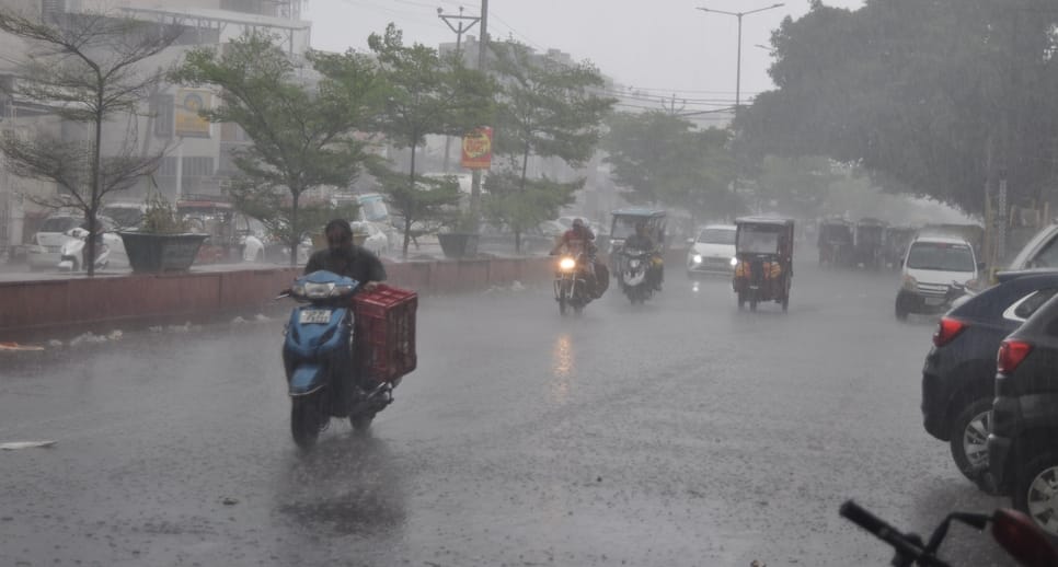 गढ़ रोड पर बारिश में सड़क पर जाते वाहन। संवाद
