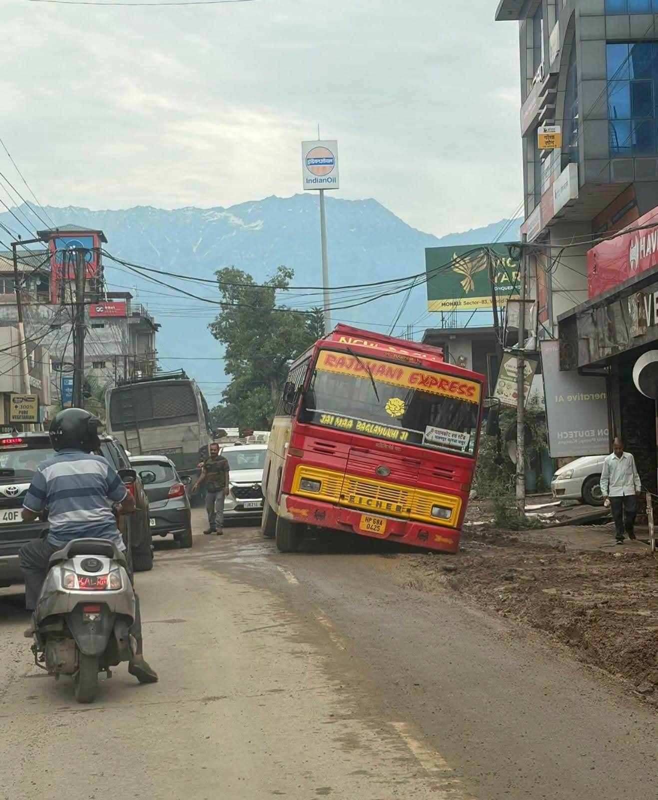 कांगड़ा के बीरता में कीचड़ में धंसी निजी बस। -संवाद
