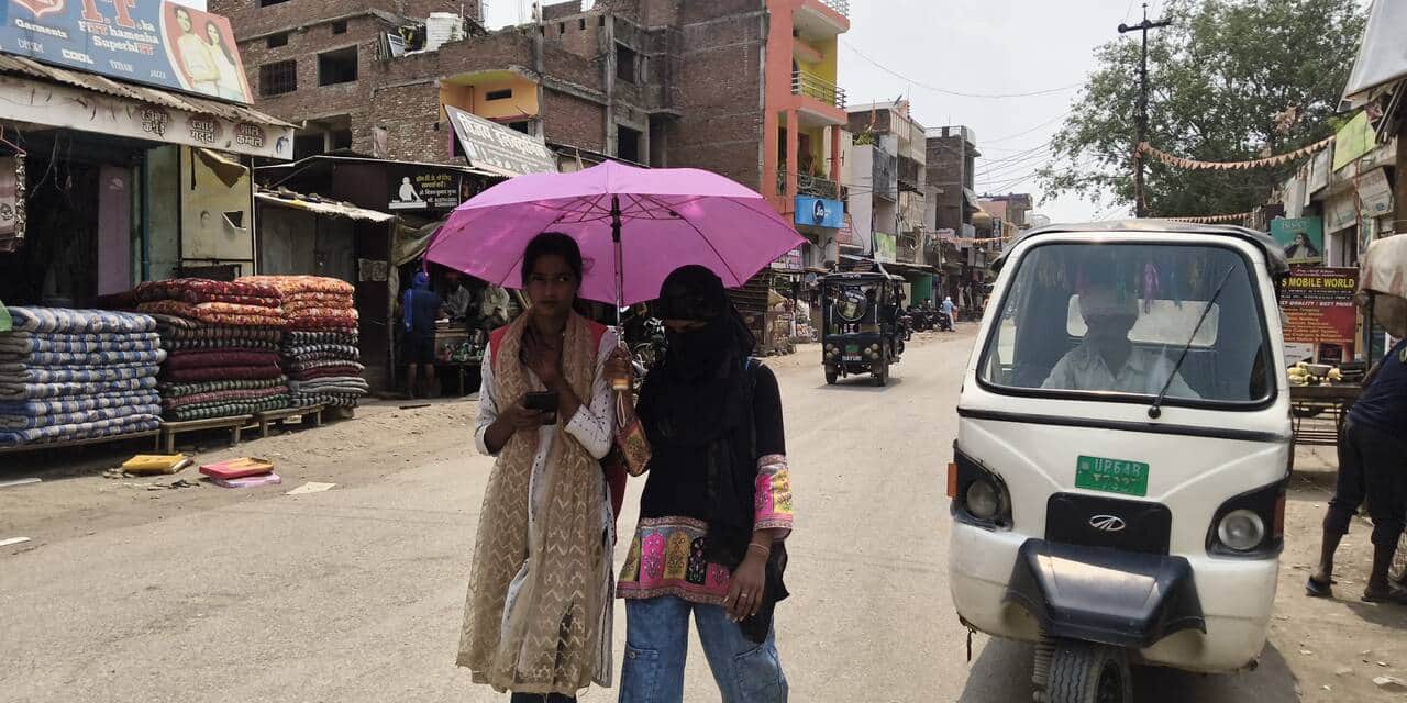 राबट्सगंज में धूप से बचने के लिए छाता लगाकर निकली युवतियां।संवाद