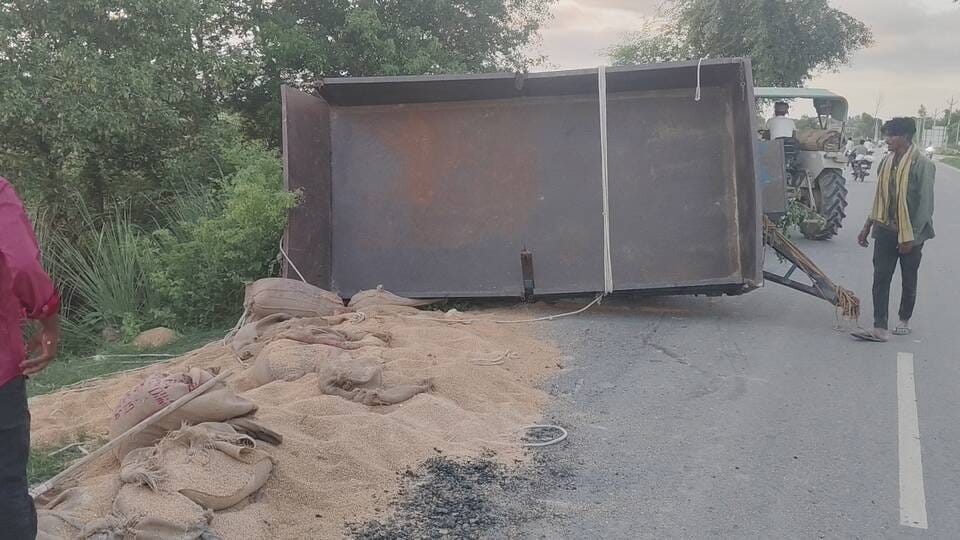 Trolley overturned, grain scattered on the road